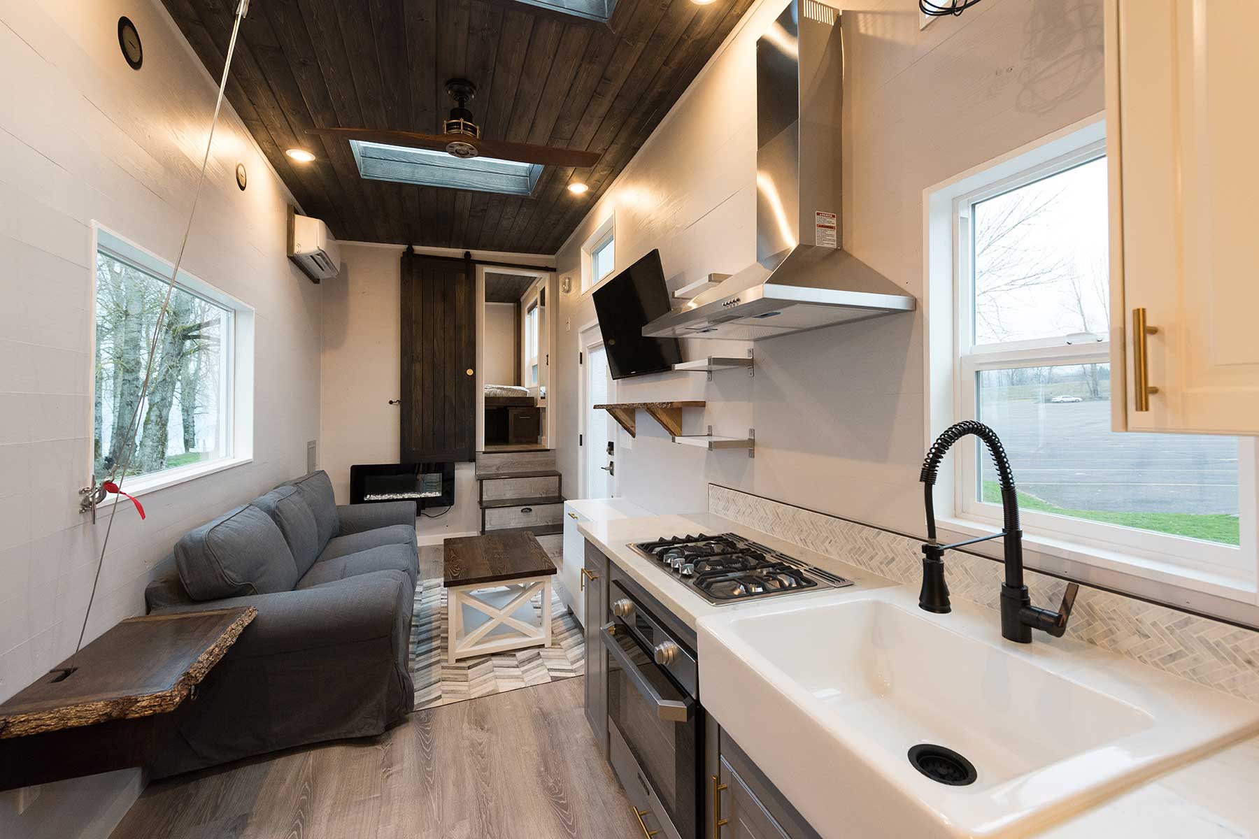 The Kingston custom tiny house's interior showing TV room and kitchen
