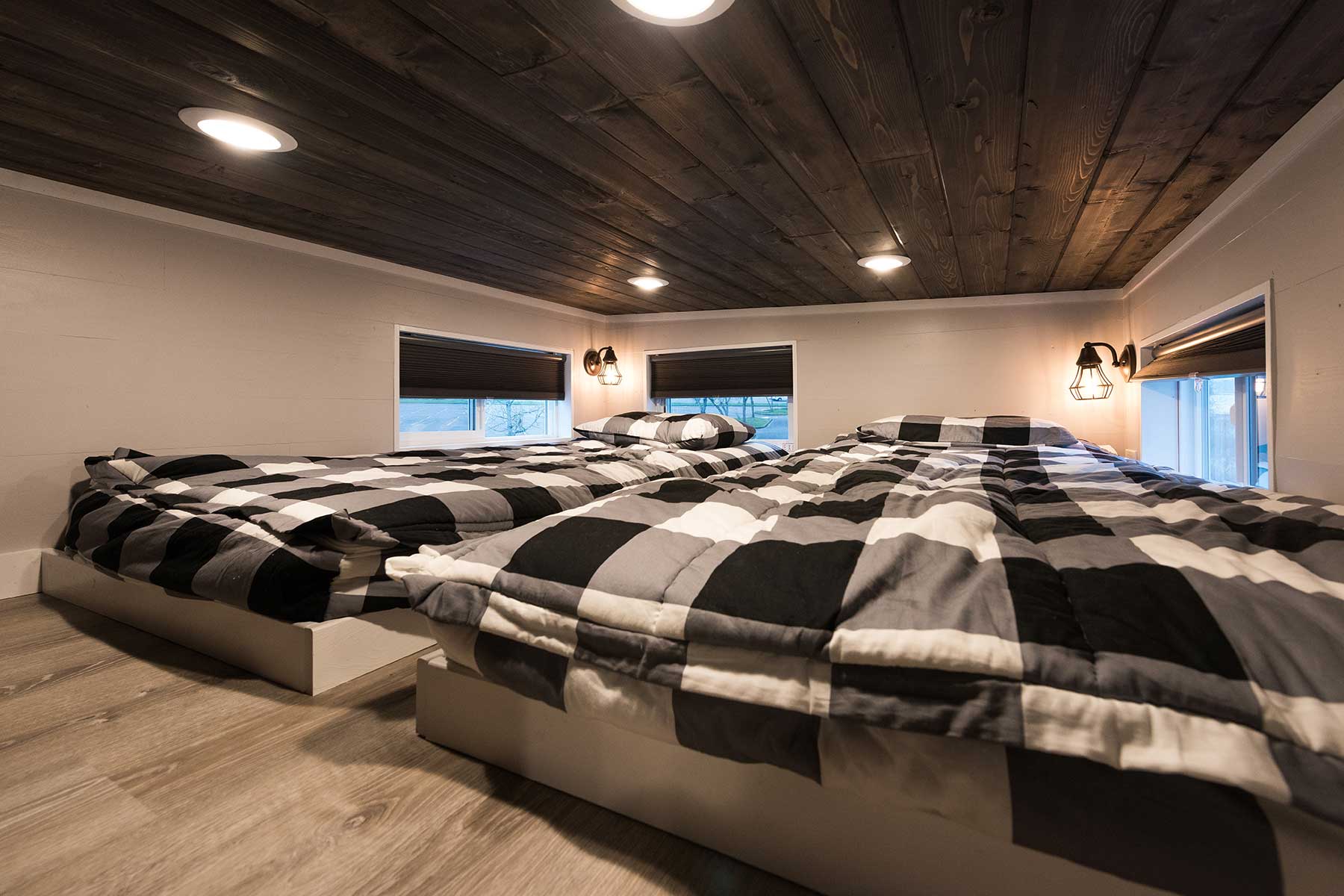 Two beds in the The Kingston custom tiny house's spacious loft