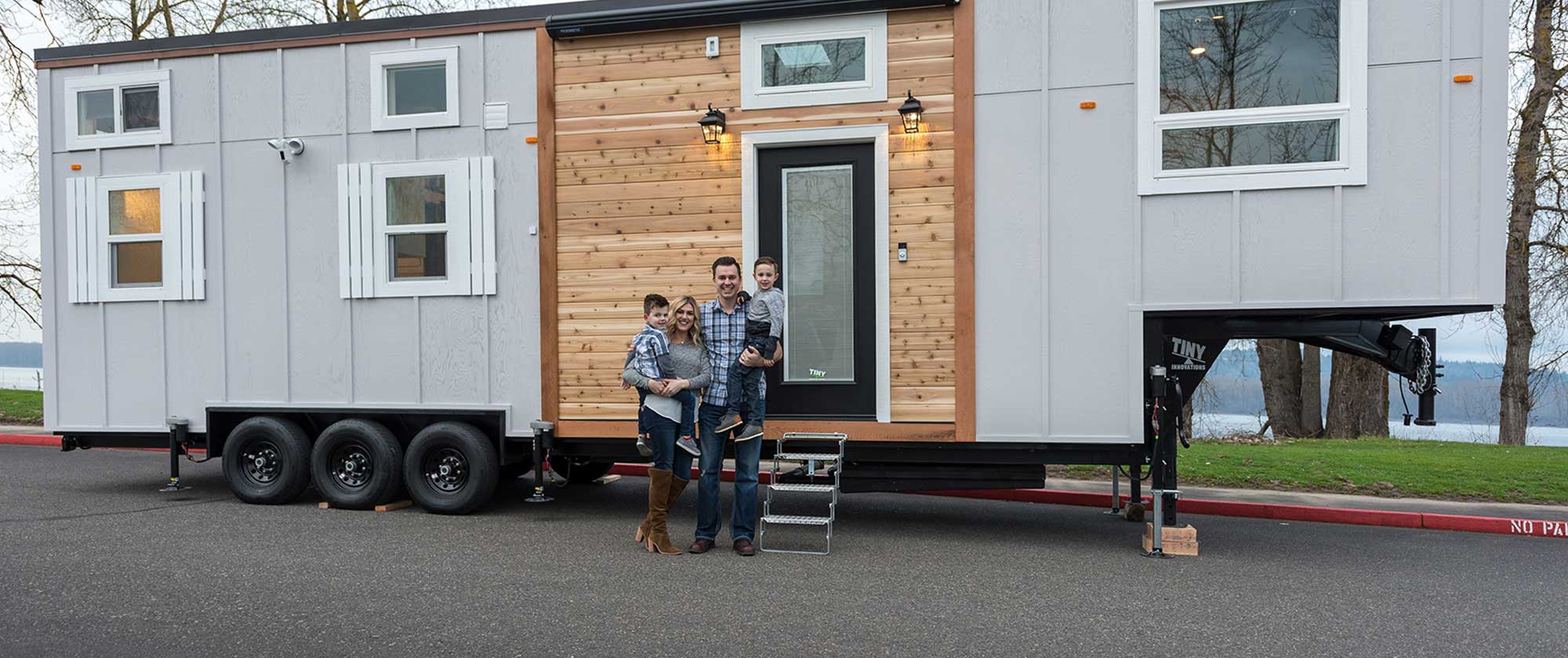 The Lawrence family poses happily in front of their Tiny Heirloom tiny home