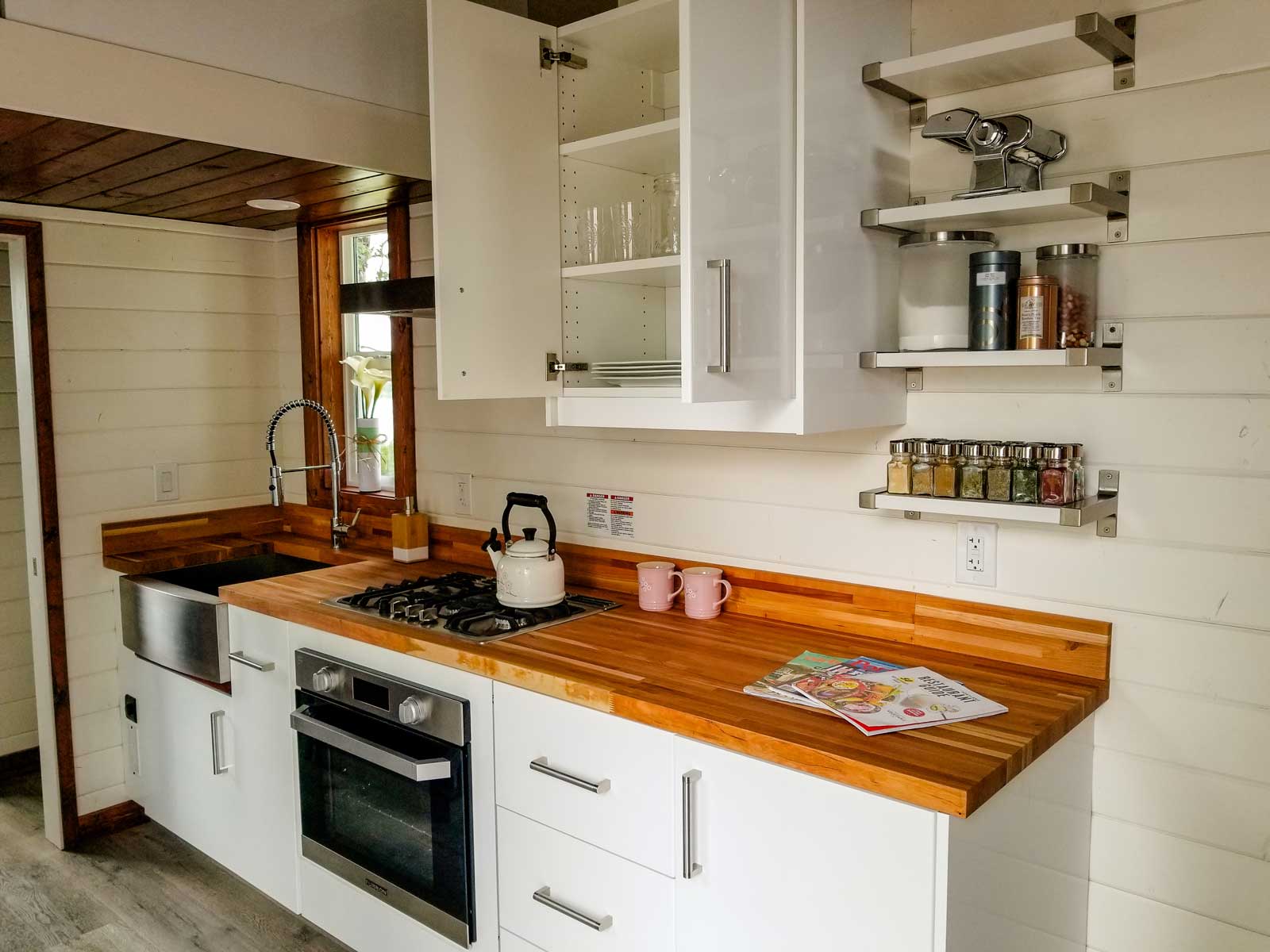 Interior of cozy cottage custom tiny house, showing the kitchen