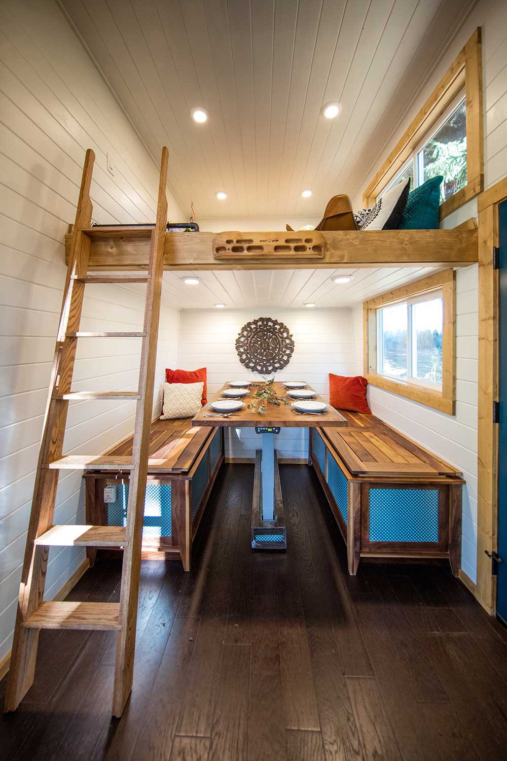 Loft with ladder and dining room in a fun custom tiny home