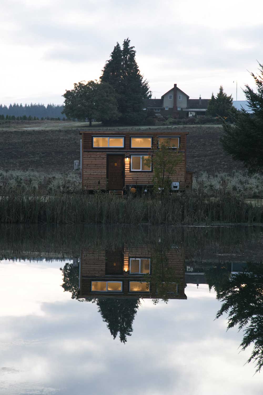 The Archway custom tiny house reflecting in a lake