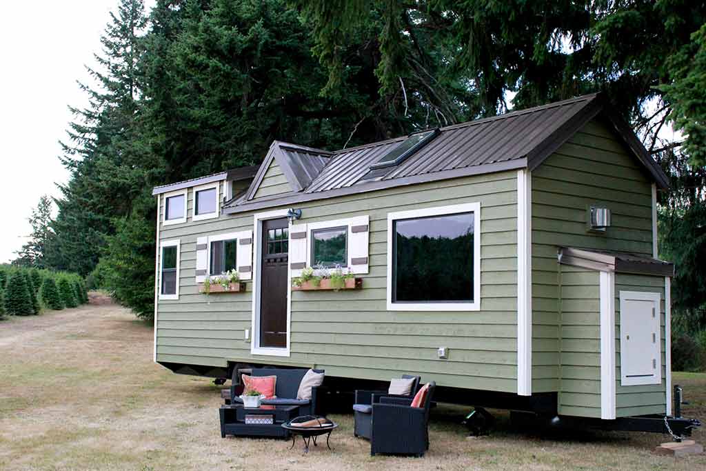 Cozy Cottage custom tiny home outside view showing windows and outside furniture