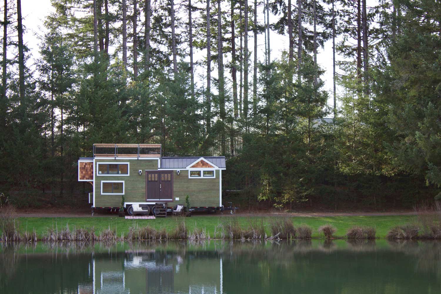 The Tiny Craftsman Home by a lake in a forest