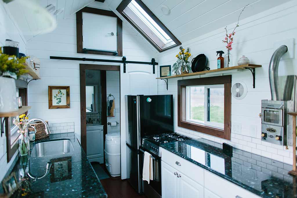 Another view of The Emerald custom tiny house's kichen and eating area, with skylights