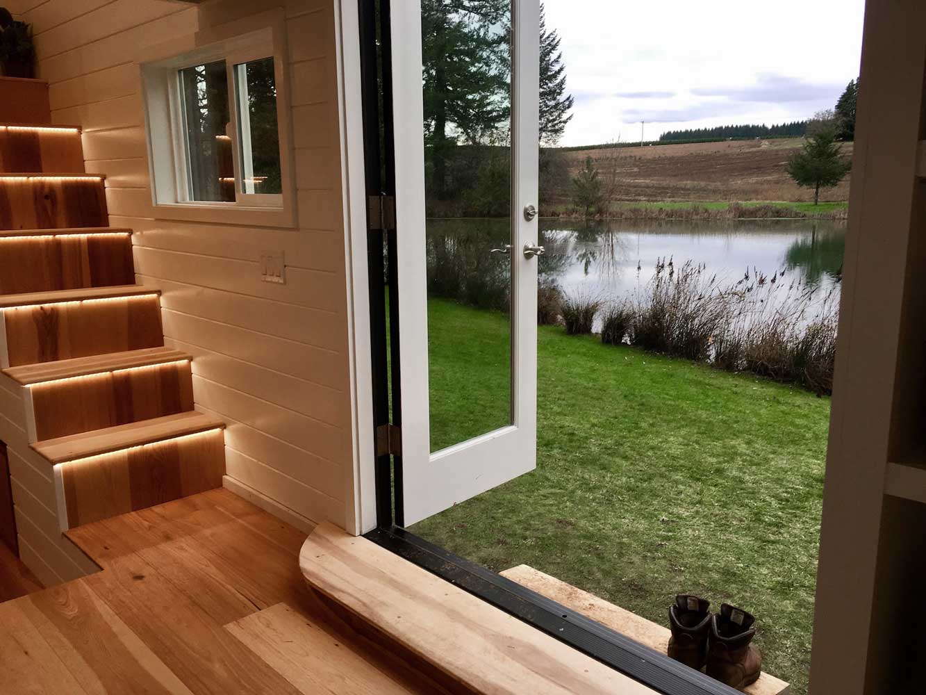 French doors opening out to a lake in the Home Of Zen custom tiny house