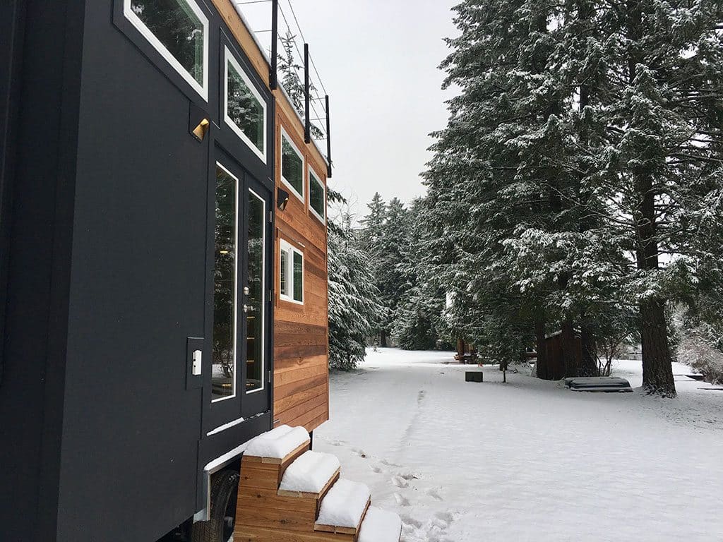 Outisde of the Home Of Zen custom tiny house in a snowy forest