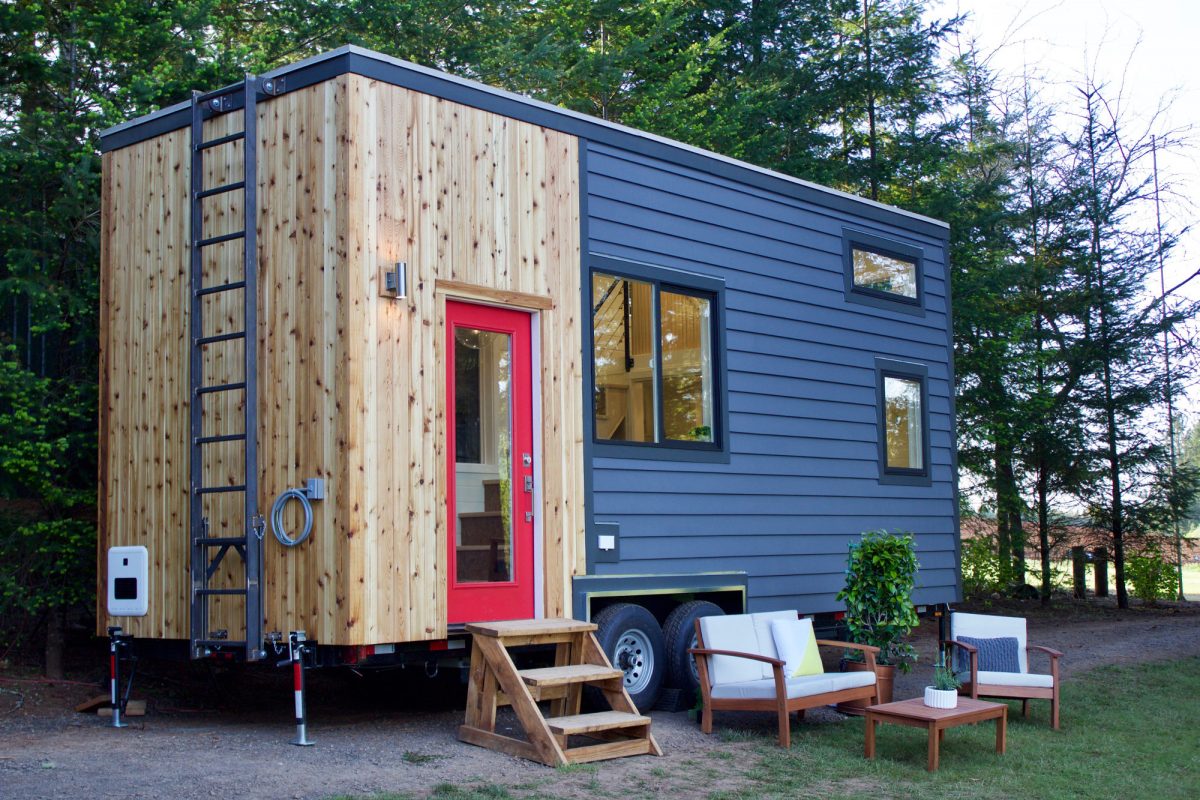 Outside of the striking wood and blue Scandinavian Simplicity custom tiny home