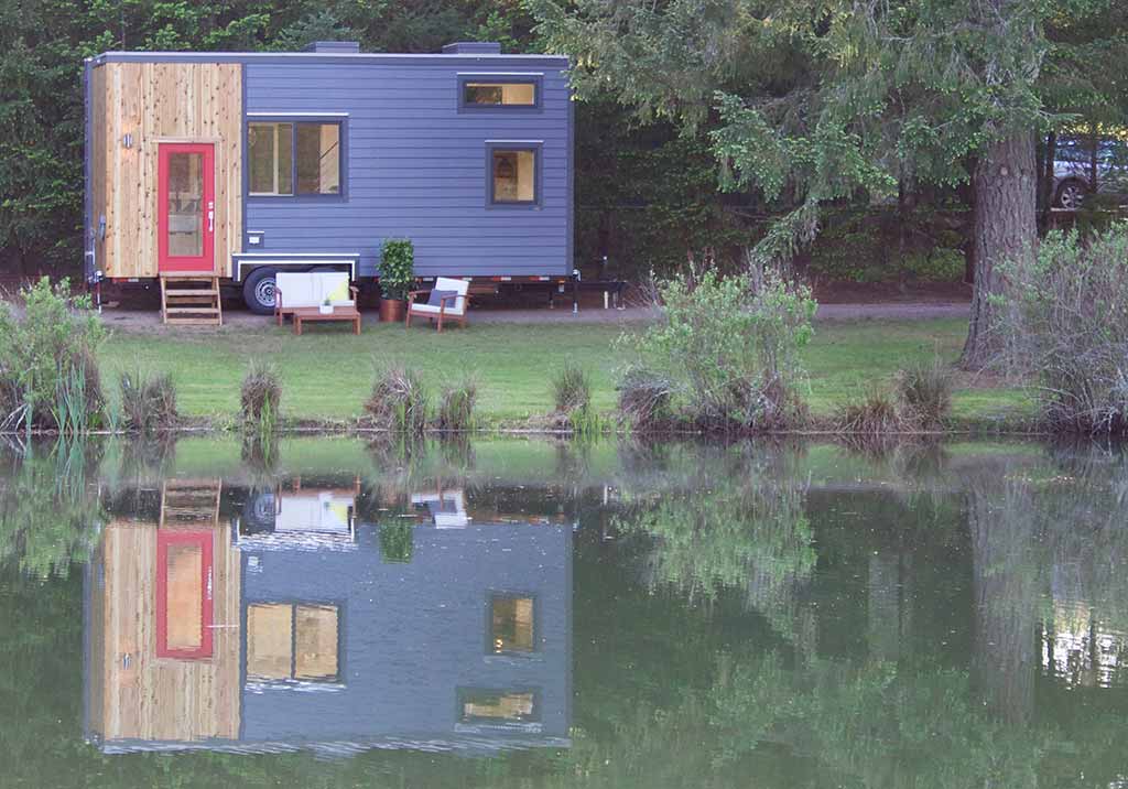 The Scandinavian Simplicity custom tiny home reflecting in a lake