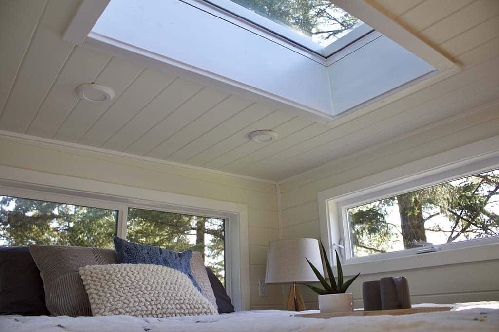 Sleeping loft in the Scandinavian Simplicity custom tiny home with skylight
