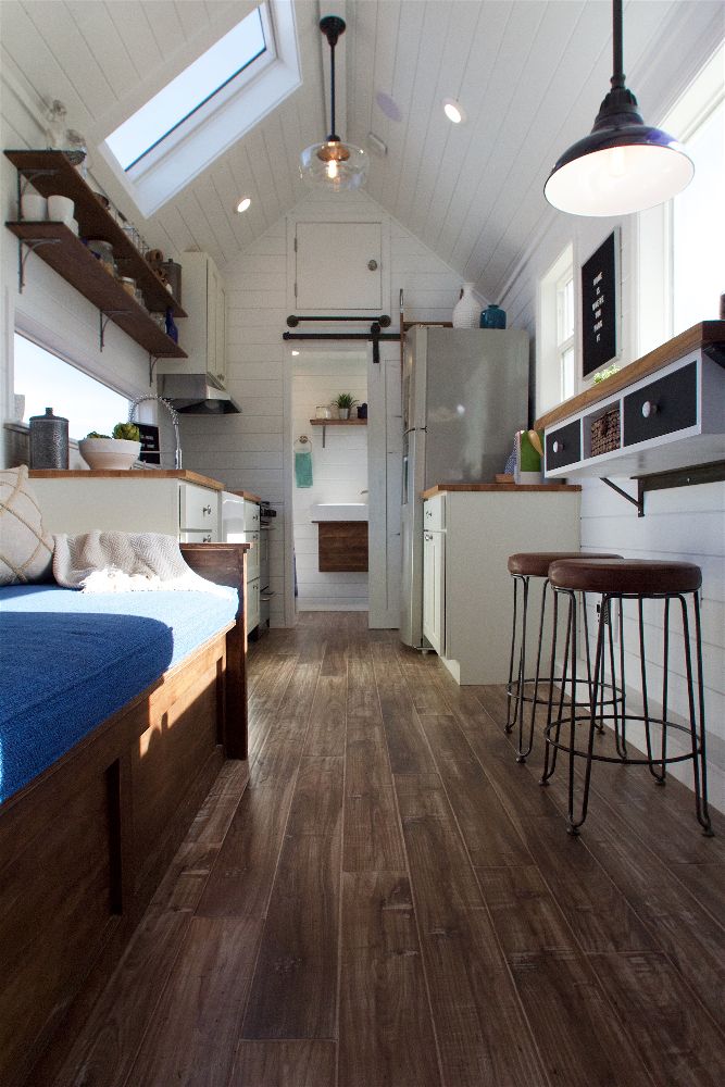 Interior of the Texan Tiny Farmhouse custom tiny home with couch, kitchen, dining counter