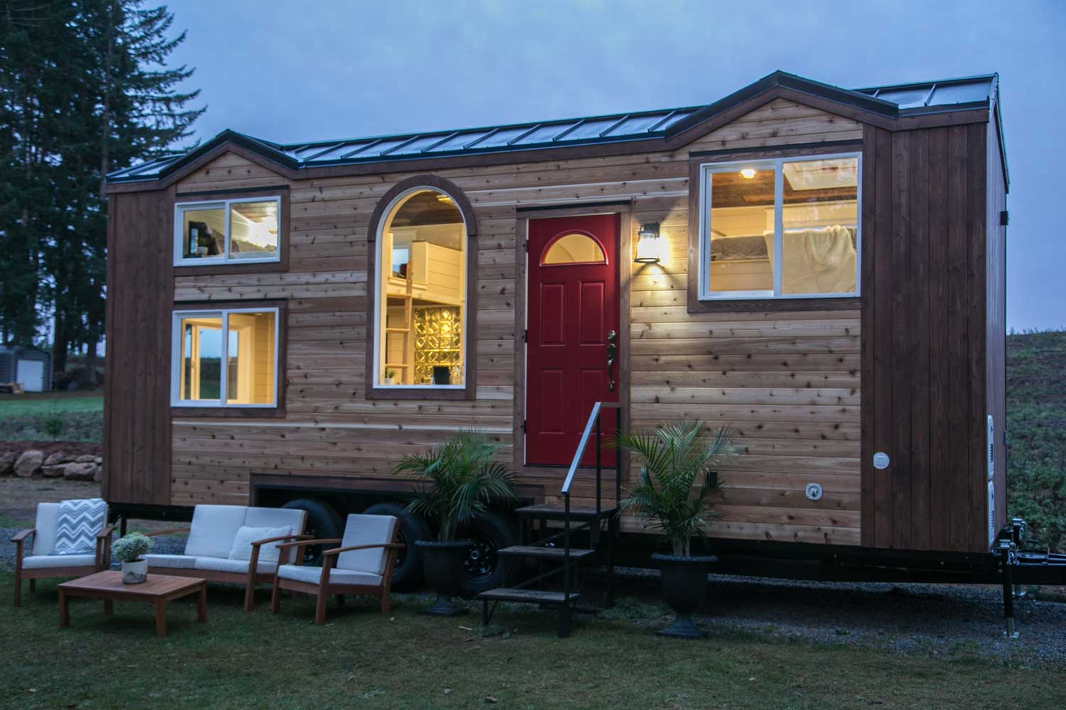 Outside view of the Theater Home custom tiny house lit up at night