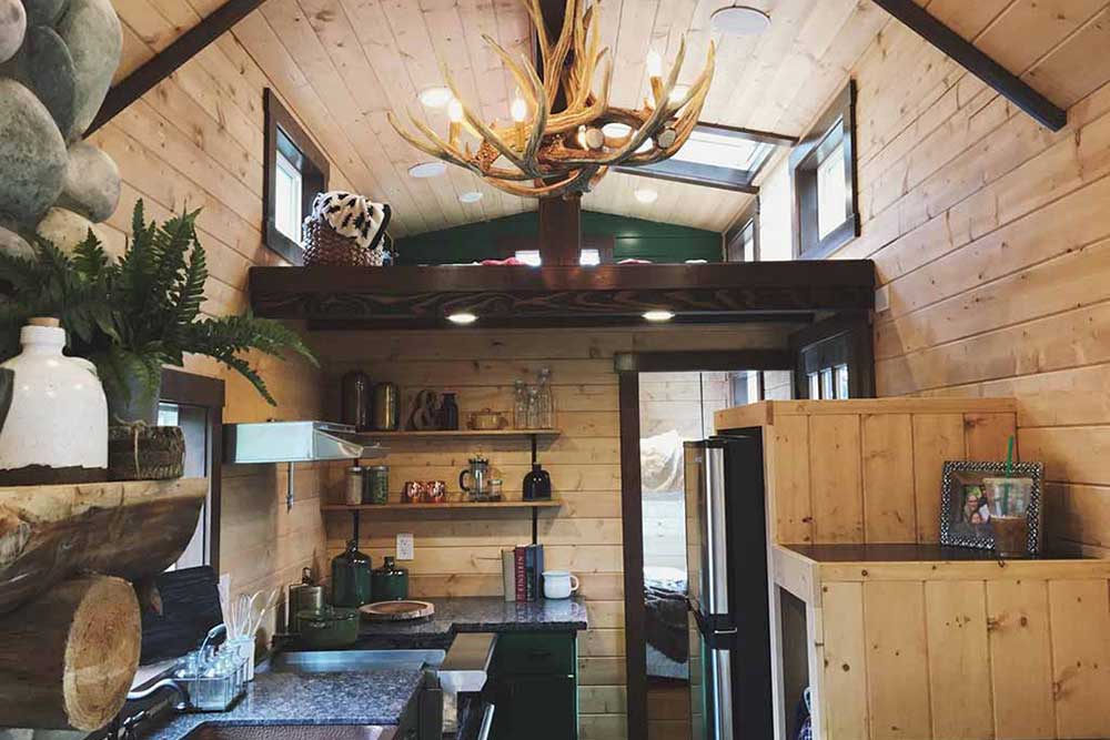 Interior of Tiny Rustic Cabin custom tiny home showing loft and kitchen