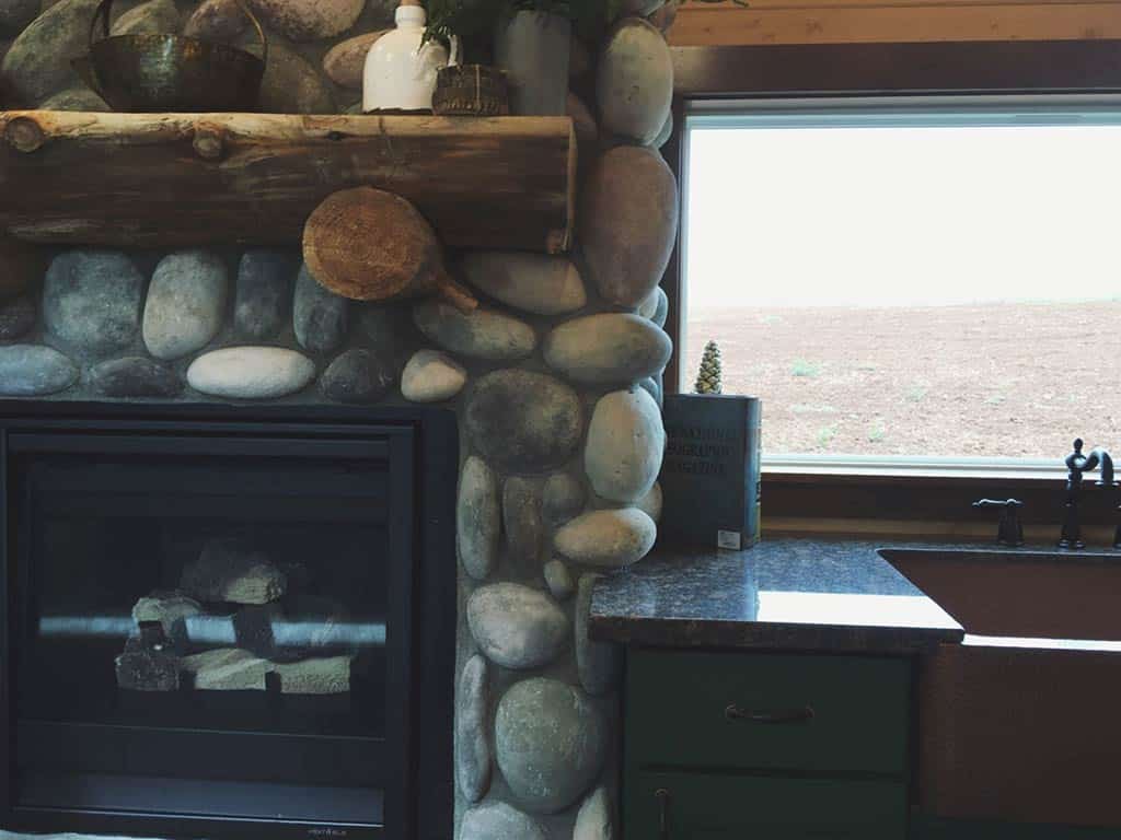 Stone fireplace detail of the Tiny Rustic Cabin custom tiny home
