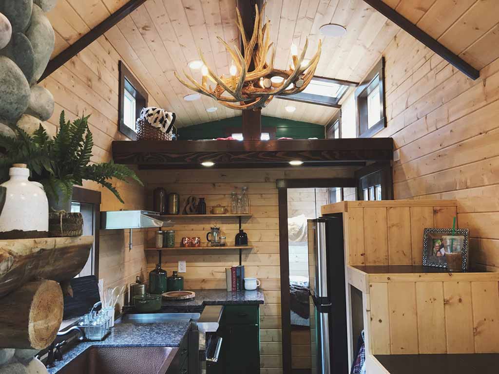 Tiny Rustic Cabin custom tiny home's interior with loft and kitchebn