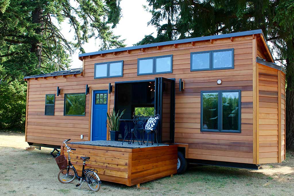 Exterior of the Tiny Home, Big Family custom tiny house showing detachable deck and bike