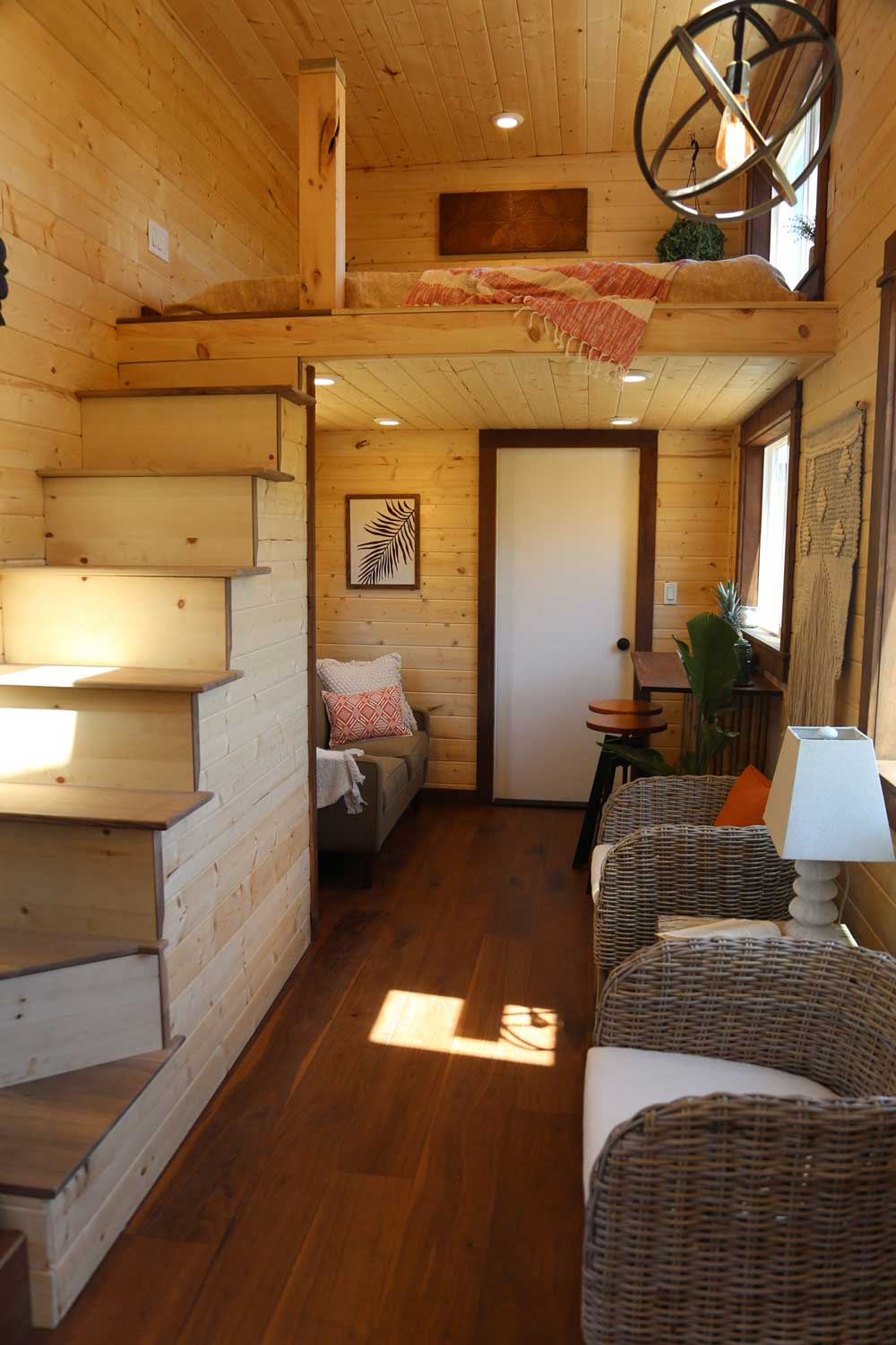 Living room and stairs to the loft in the Tropical Getaway custom tiny house