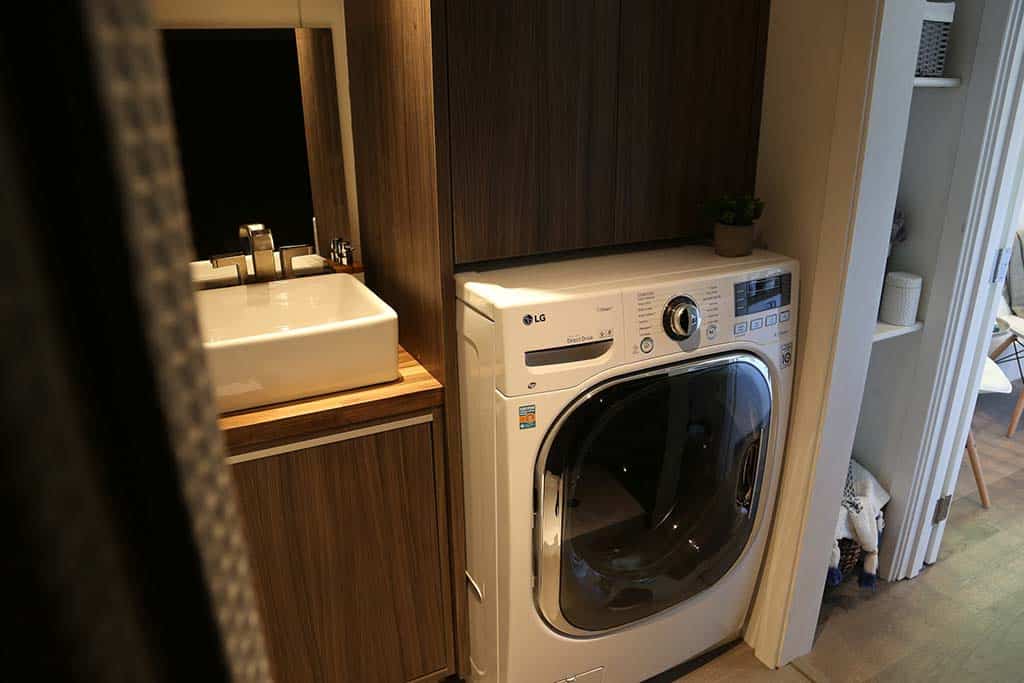 Washing machine and sink in the The Ultra Modern custom tiny home