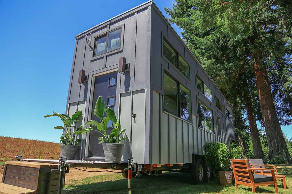 The Ultra Modern custom tiny home outside back view with potted plants