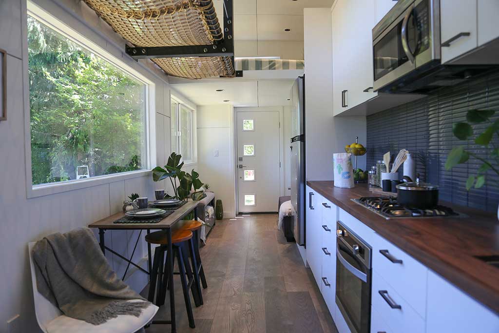 Interior of The Ultra Modern custom tiny home showing kitchen and eating counter