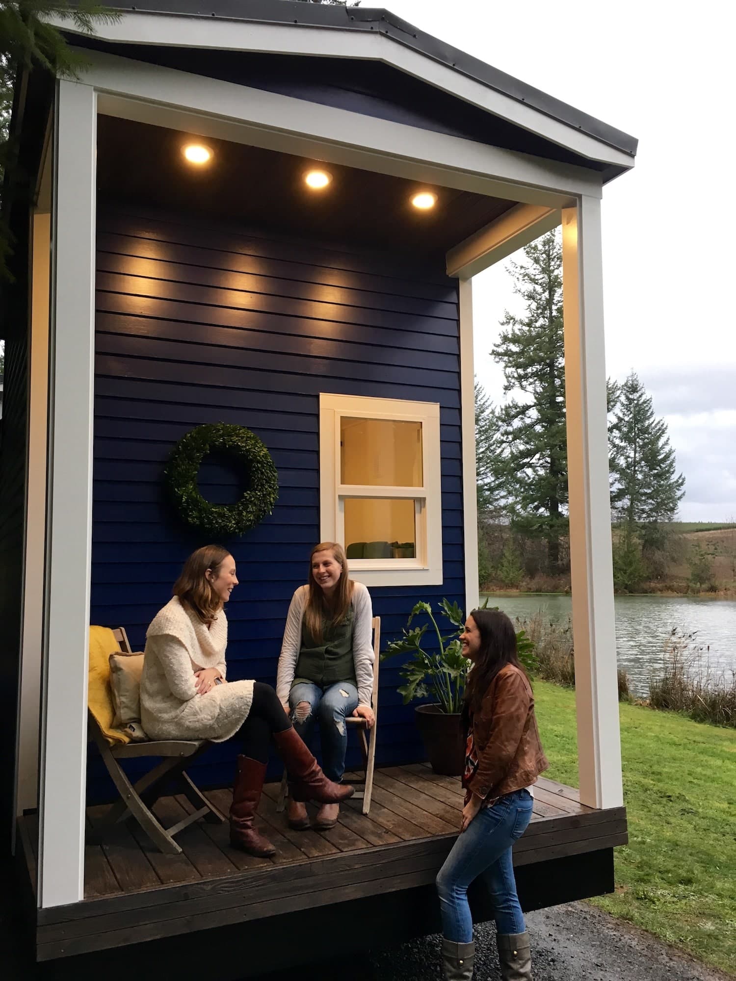 People socializing on the porch of the Vintage Glam custom tiny home