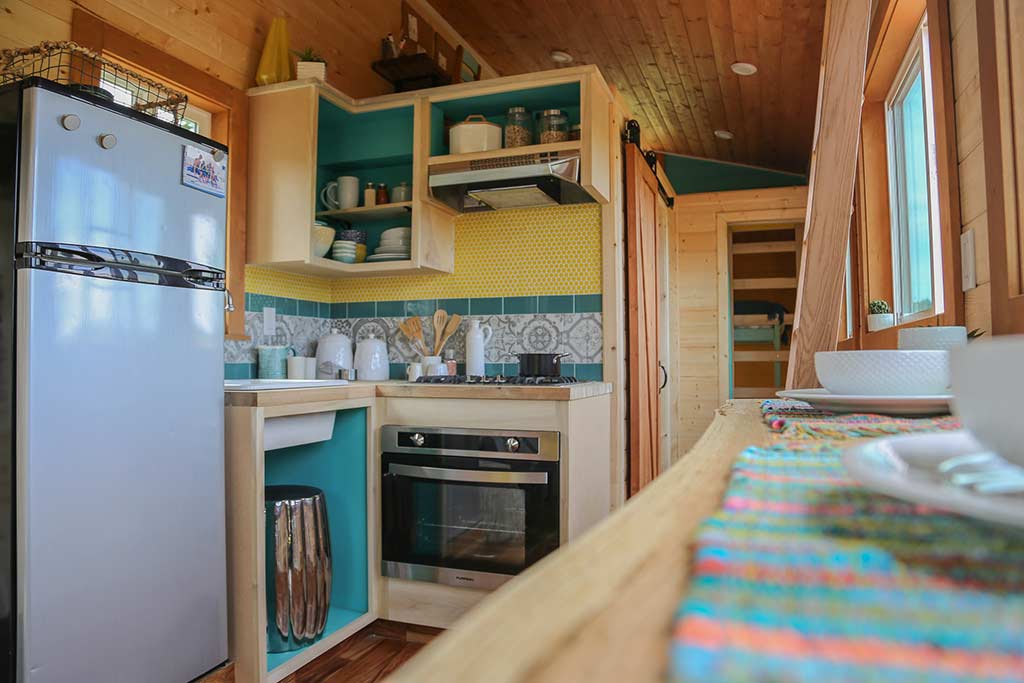 Colorful kitchen and dining counter in the Beachy Bohemian custom tiny home