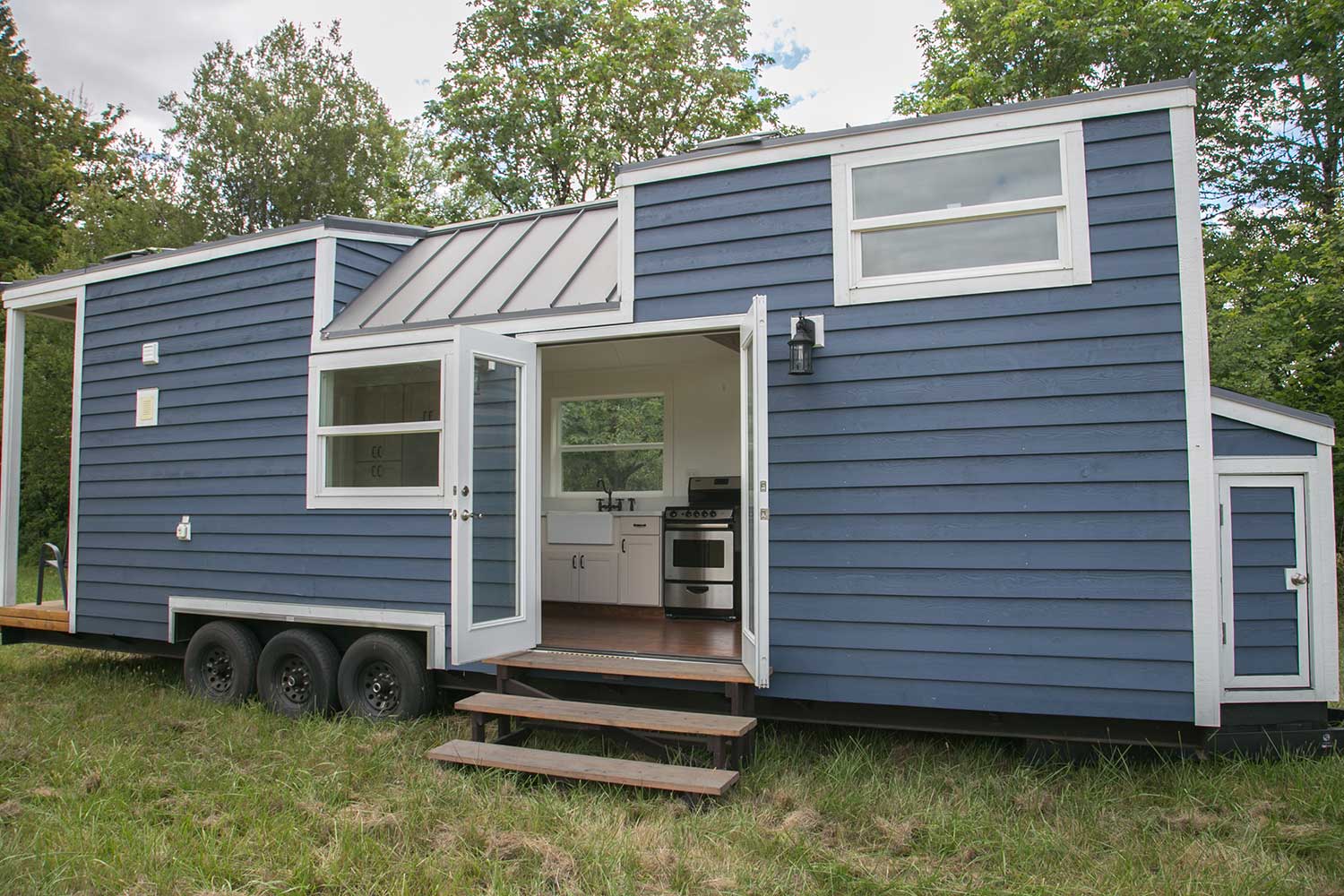 Outside of the Maribelle Blue custom tiny home showing its double french doors