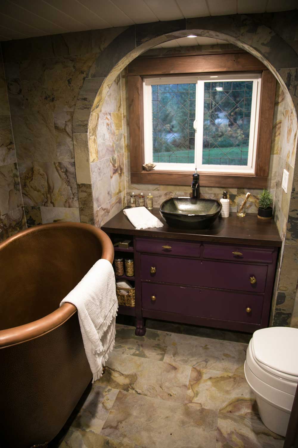Bronze bathtub and writing desk in the unique custom tiny home Tudor