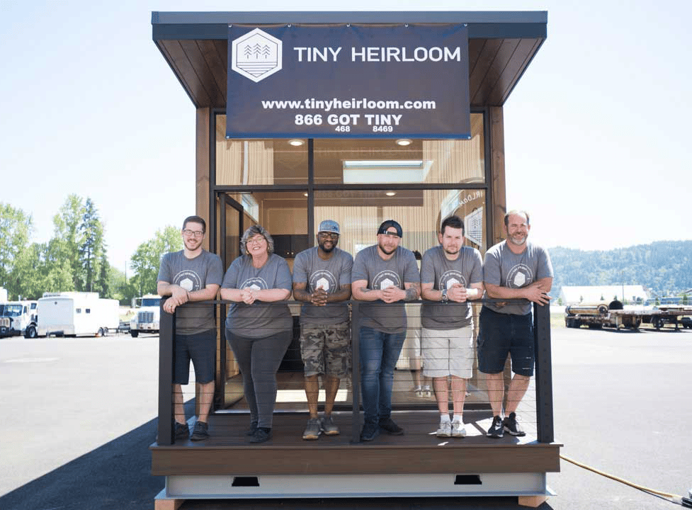 The Tiny Heirloom team poses in front of one of their tiny home models