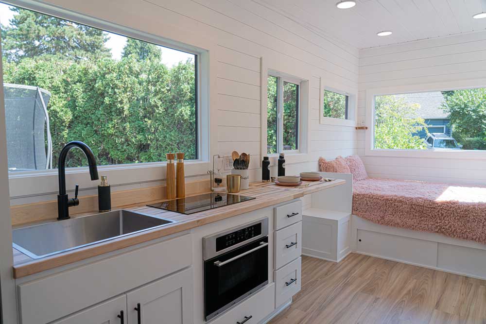 Interior of a Legacy tiny house, showing kitchen and window seat