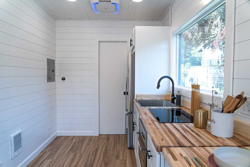 Interior of a Legacy tiny house model showing a kitchen and big window