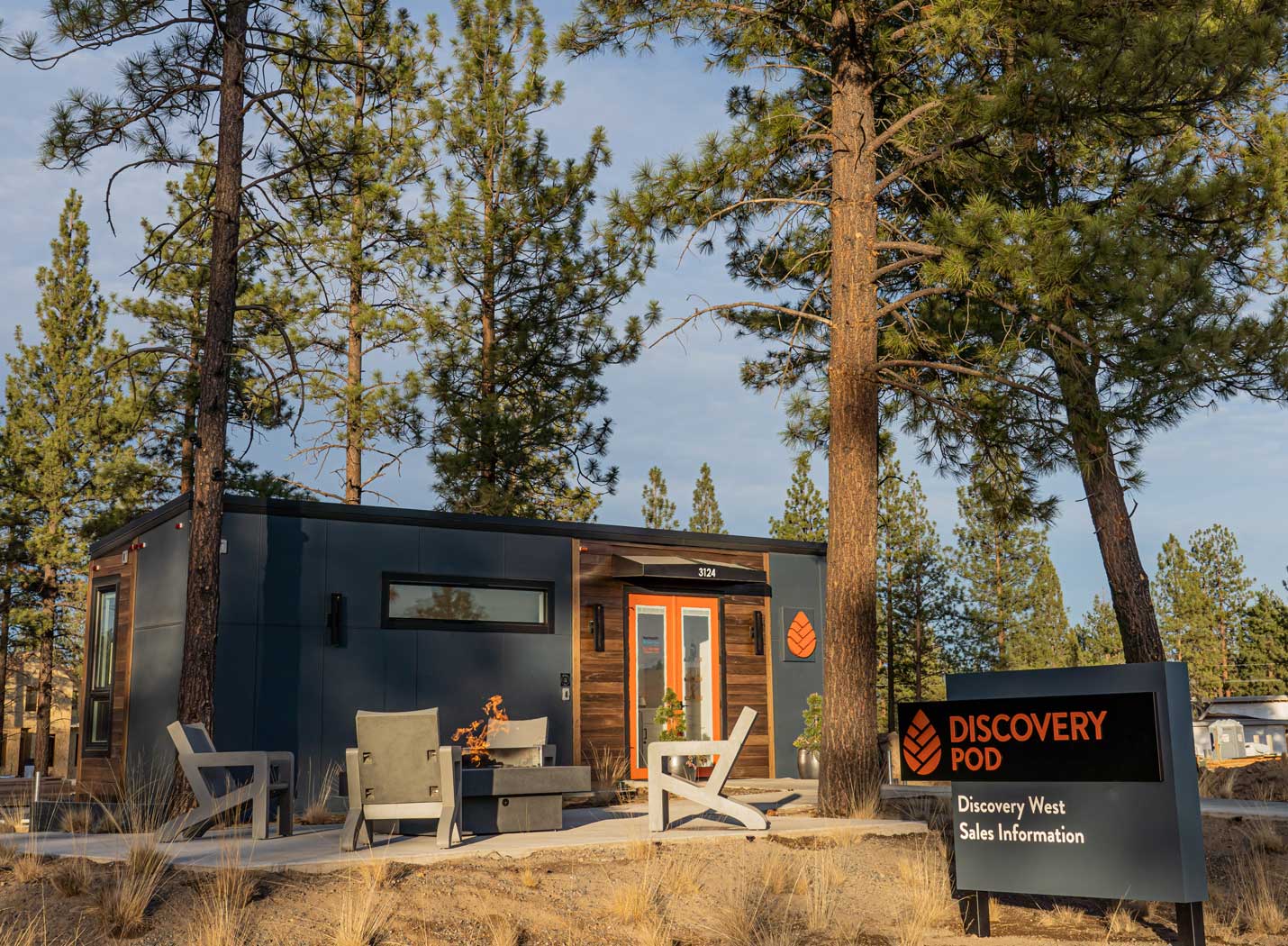 Outside view of Latitude tiny home put to a commercial use, set among big trees