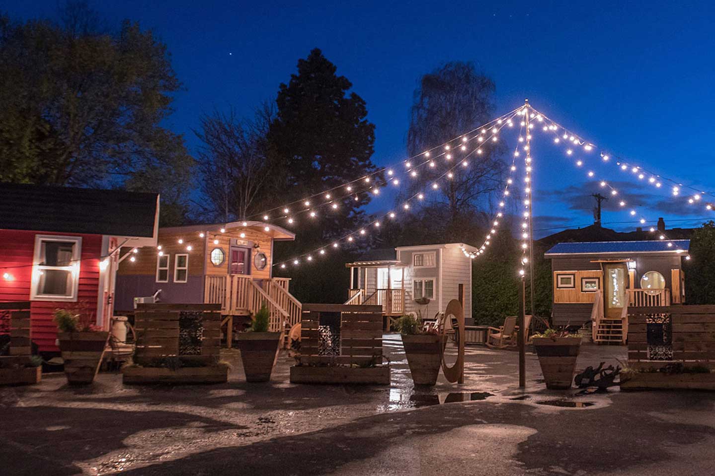 A tiny house hotel at night light by festive lights
