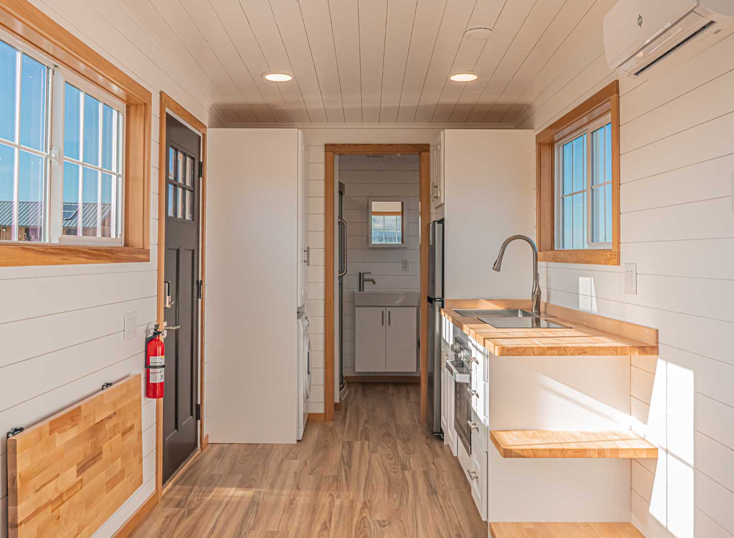 Interior of Legacy Tiny Home for sale as part of Tiny Heirloom's Signature Series tiny house models. Shows kitchen and bathroom in the craftsman style