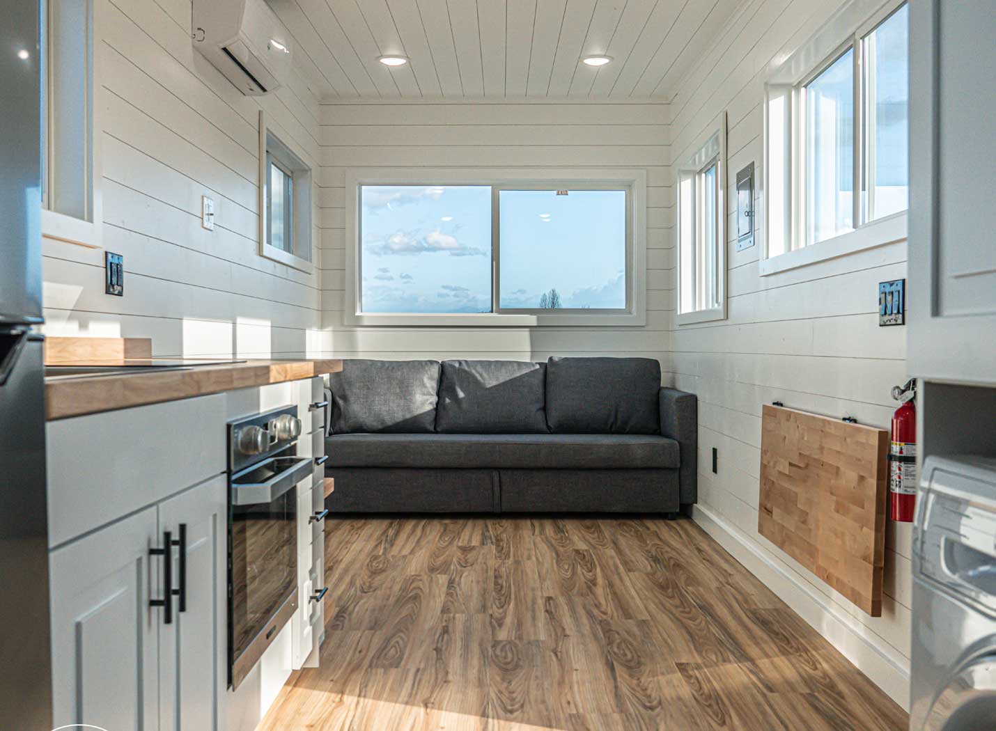 Interior of a Legacy tiny home model in the farmhouse style, showing kitchen and sofa