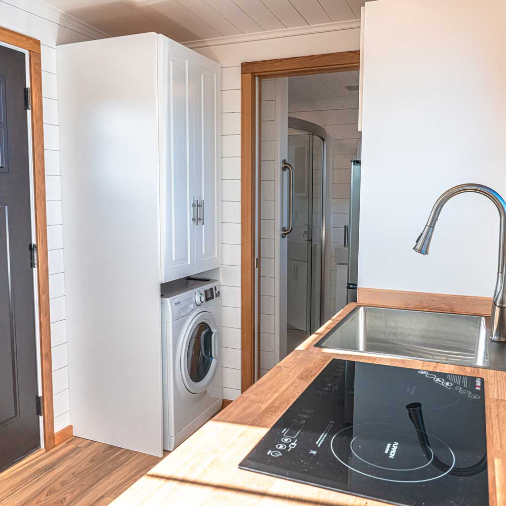 Kitchen and washer / dryer combo in the interior of a Legacy tiny house
