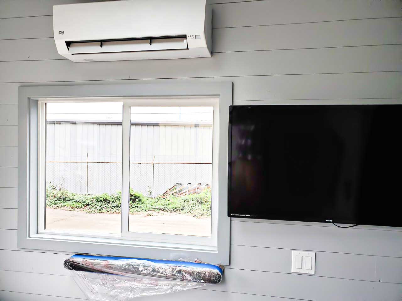 WIndown, TV and heat pump in the True Blue custom tiny home