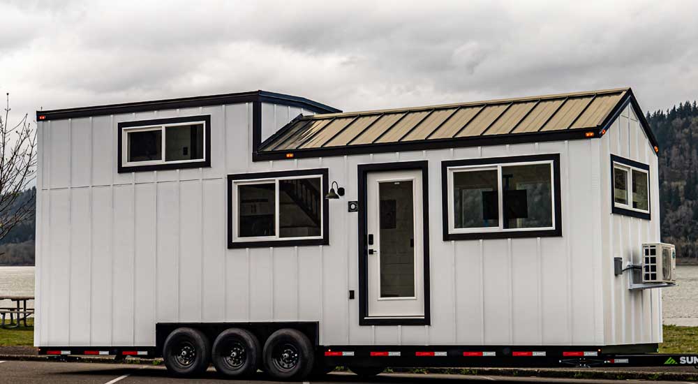 A farmhouse style Heritage tiny home outside view on a cloudy day