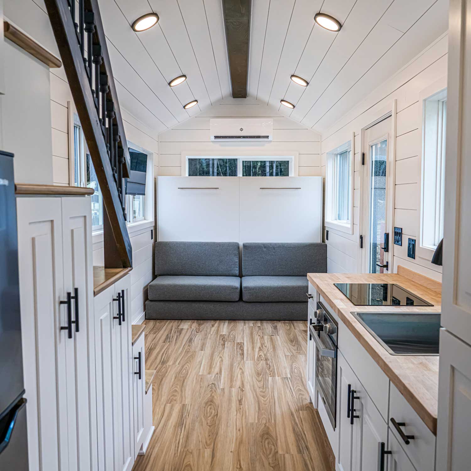 Interior of farmhouse style Heritage tiny home with couch and kitchen