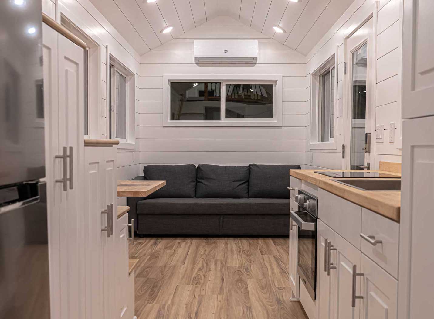 Heritage tiny house model interior showing kitchen and sofa