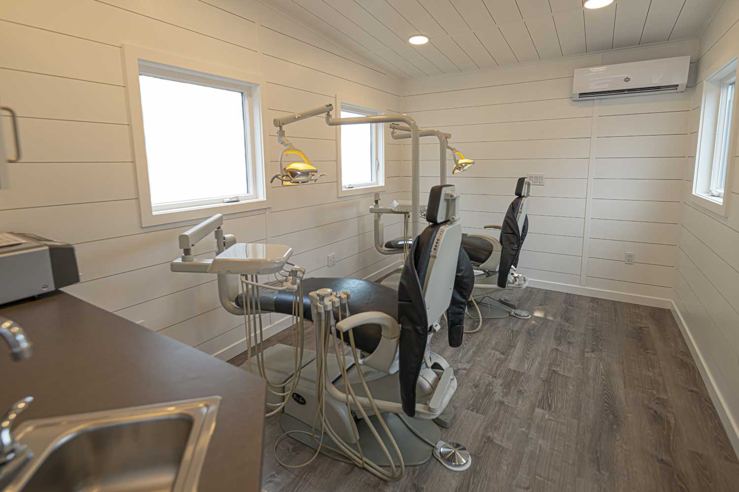 Interior of the Gentle Dental Mobile Dentists office commercial tiny home, showing windows, a mini split heat pump, and dentist chairs and eqiupment